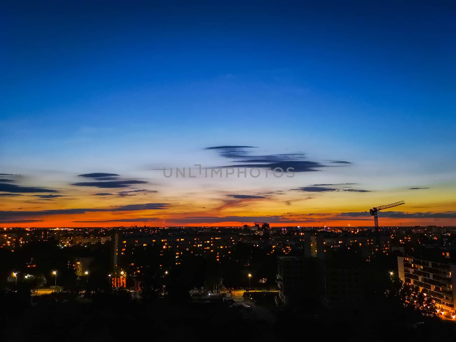 Blue and orange cloudy sky just after sunset and citylights by Wierzchu