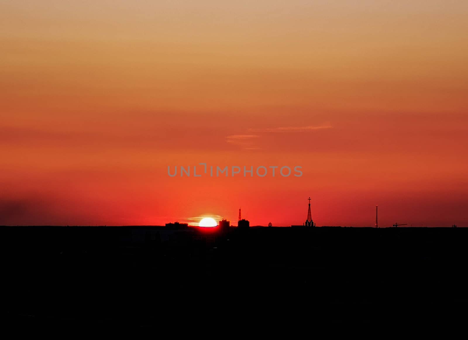 Sun hiding behind horizon at sunny golden hour