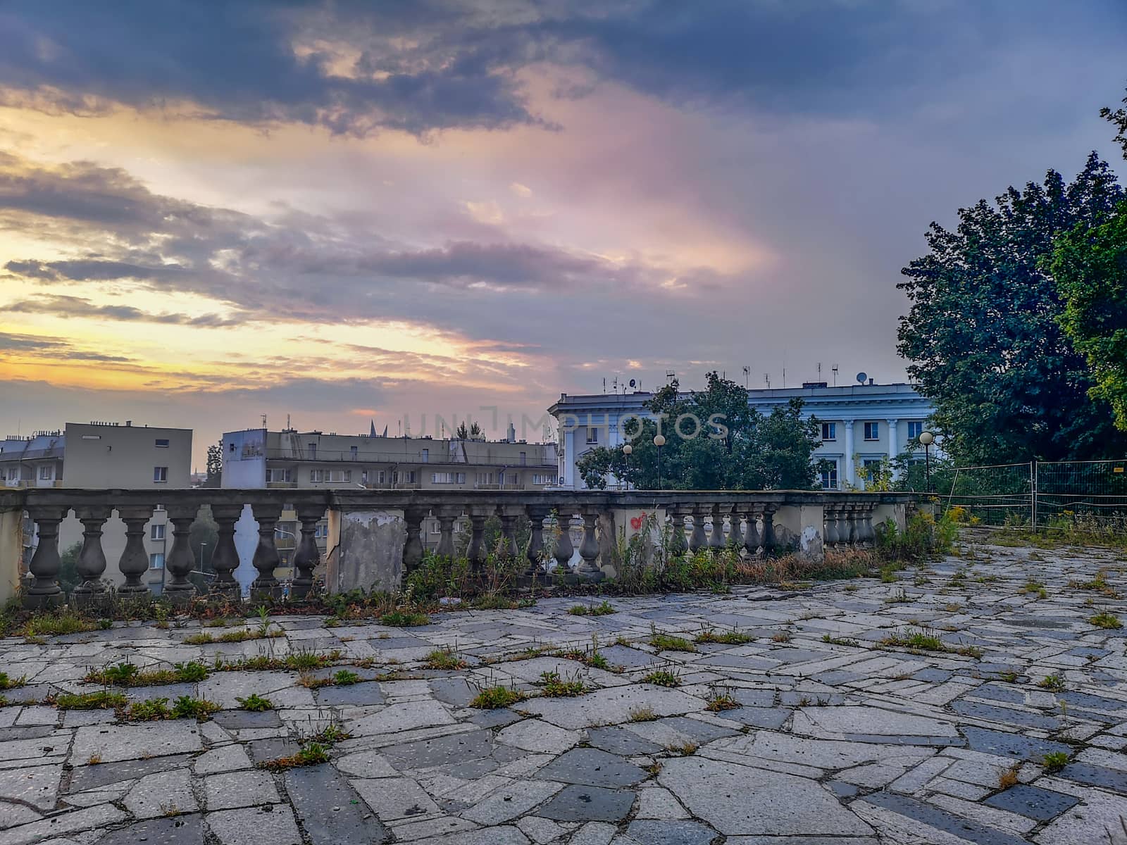 Purple sunset over old building ruins with concrete barrier by Wierzchu