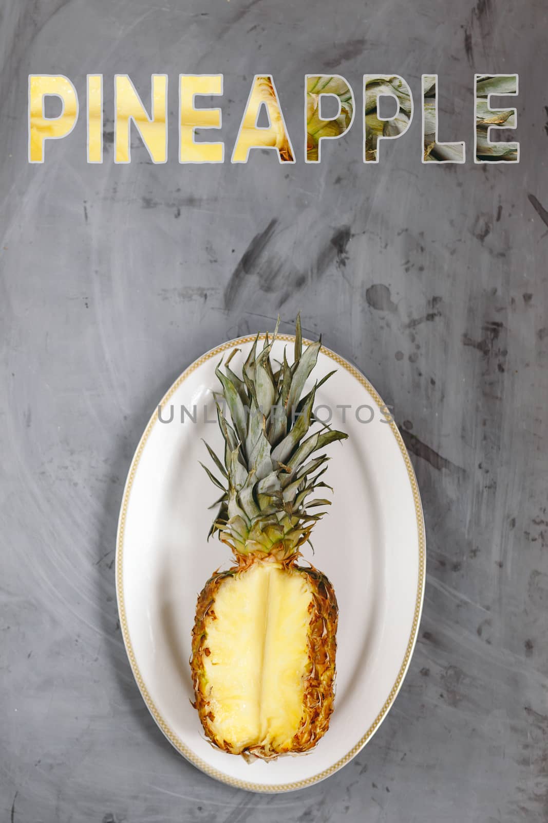 White Plate with Ripe Sliced Pineapple on Grey Concrete Background. Word Pineapple