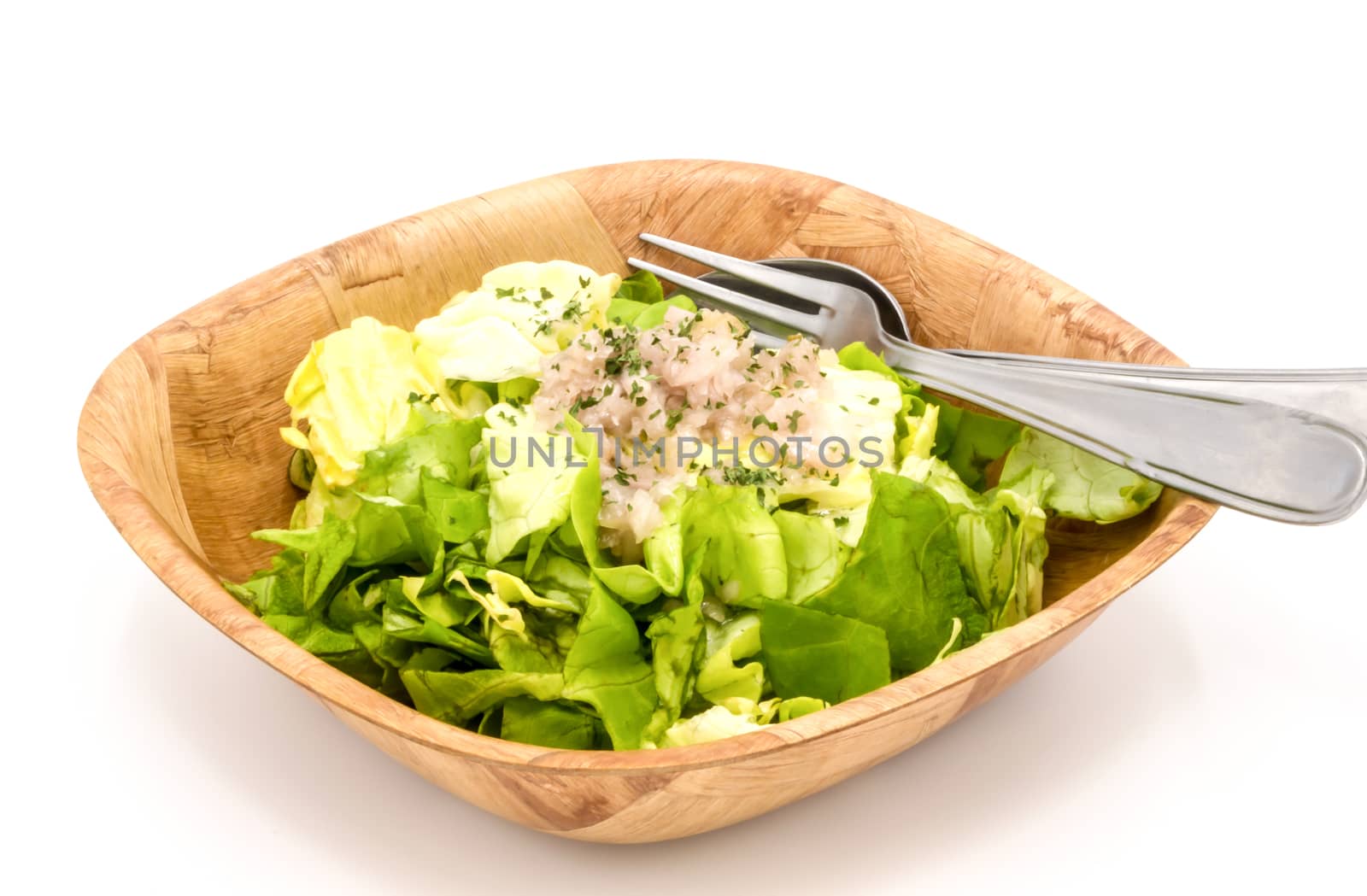 fresh green lettuce salad in a bowl isolated on a white background.