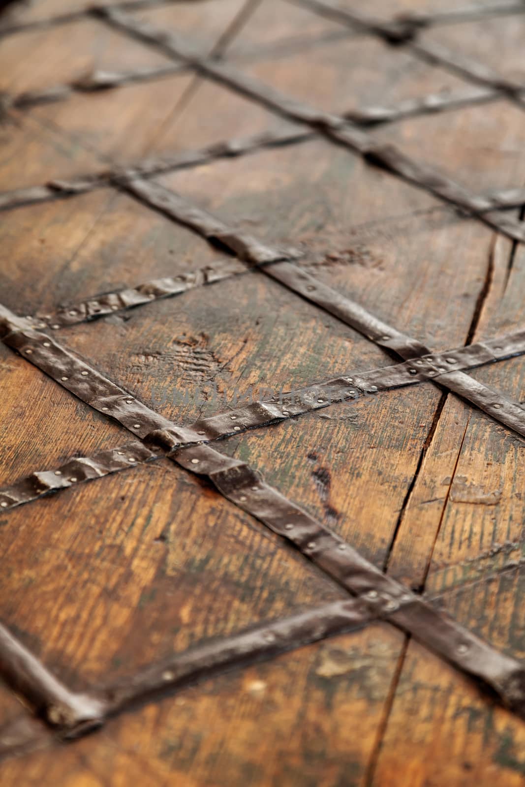 Fragment of an old brown wooden chest. Wood and forged metal on the chest cover.