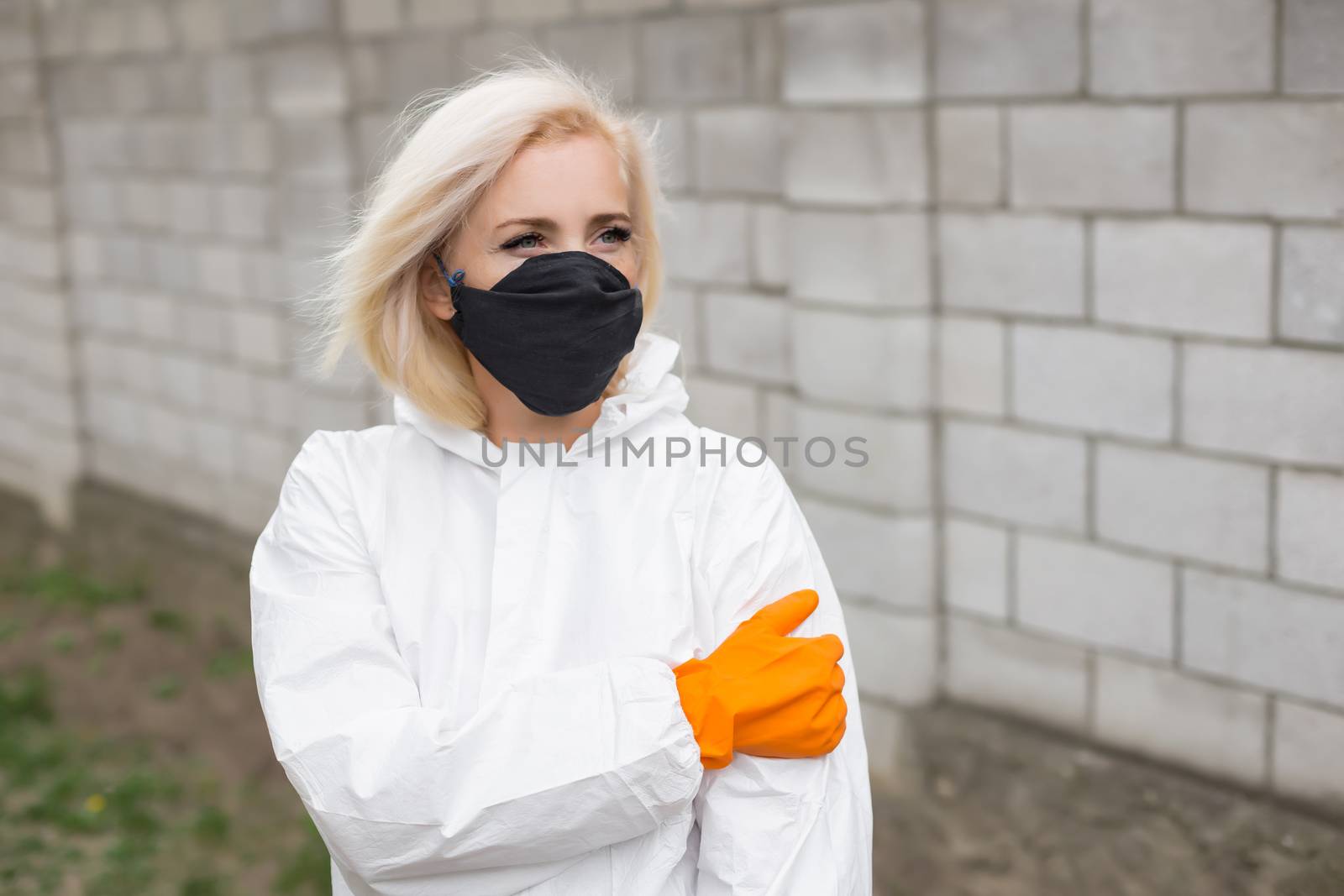 Woman in black mask, white protective suit and gloves