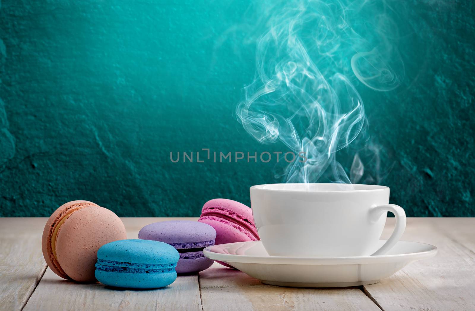 Macaroons with coffee on wooden table with background. Turquoise background