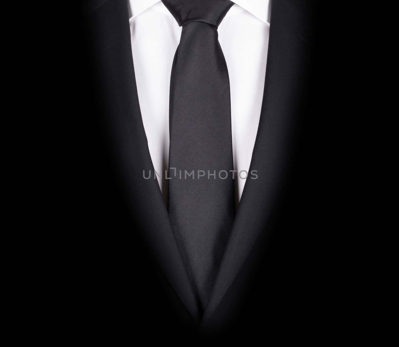 Man in a black suit with black tie, close-up