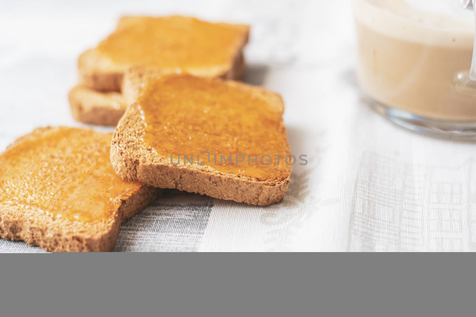 group of biscuits with jam spread with a cup of cappuccino on a table with the decorated tablecloth. Morning breakfast. Healthy food and lifestyle