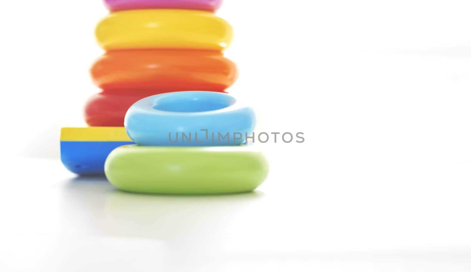 Colorful plastic rings on a white background to be stacked in a tower. Toy for newborns.