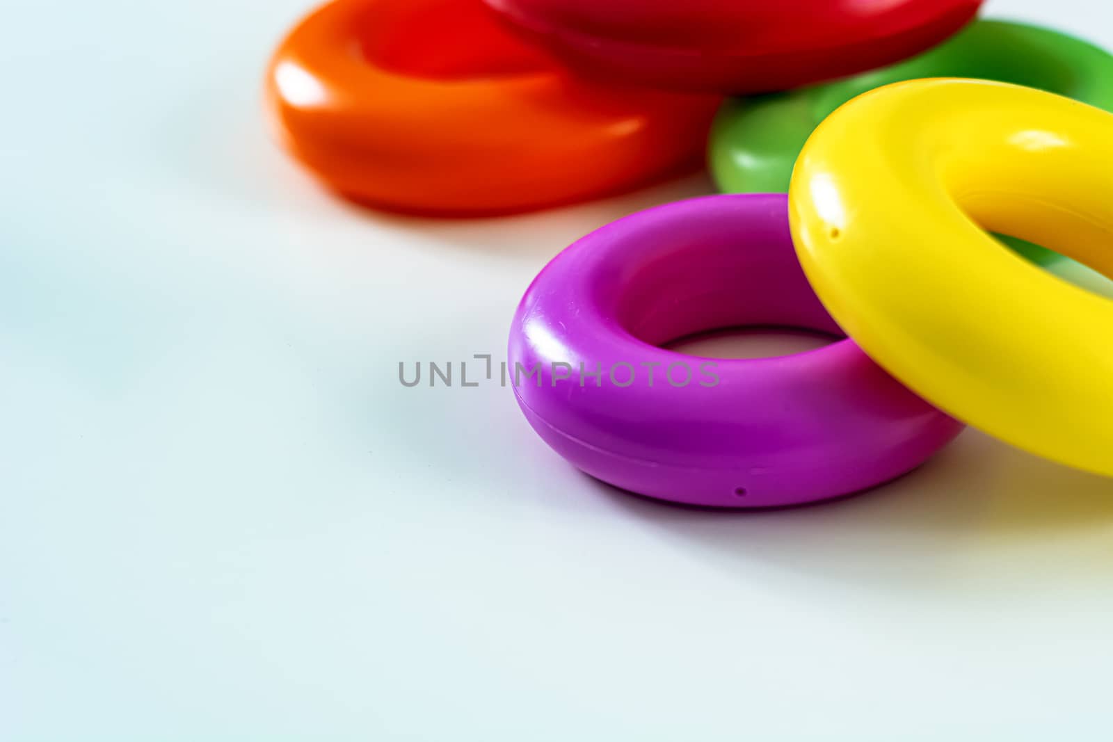 Colorful plastic rings on a white background to be stacked in a tower. Toy for newborns.