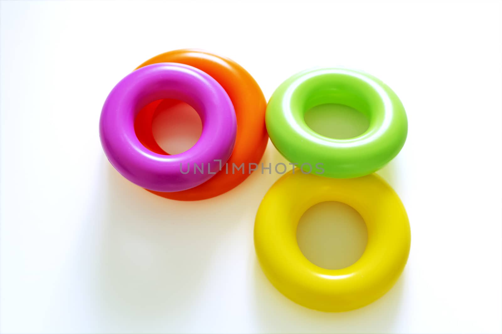 Colorful plastic rings on a white background to be stacked in a tower. Toy for newborns.