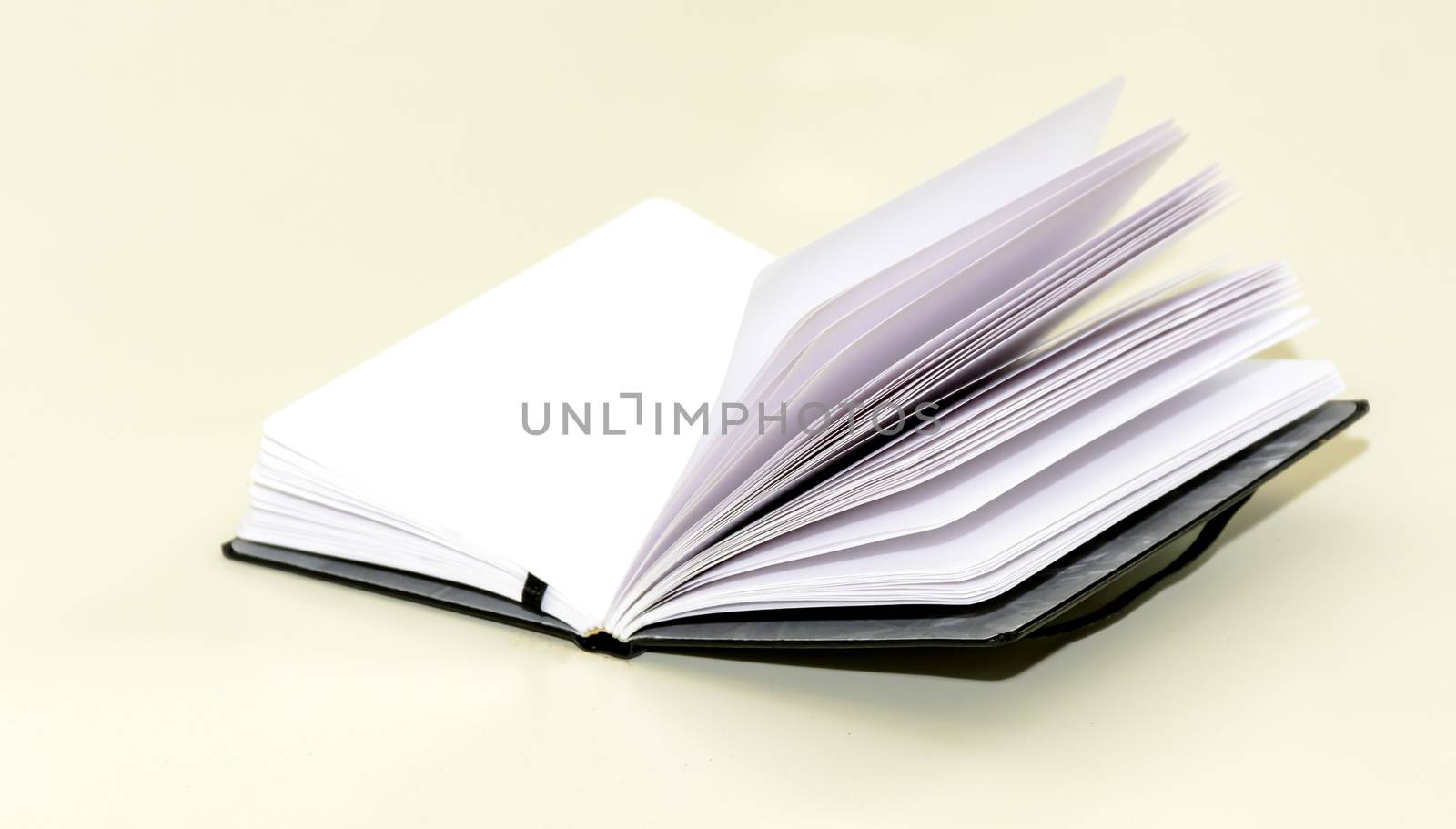 open hardcover notebook on a white table. Unwritten blank pages.