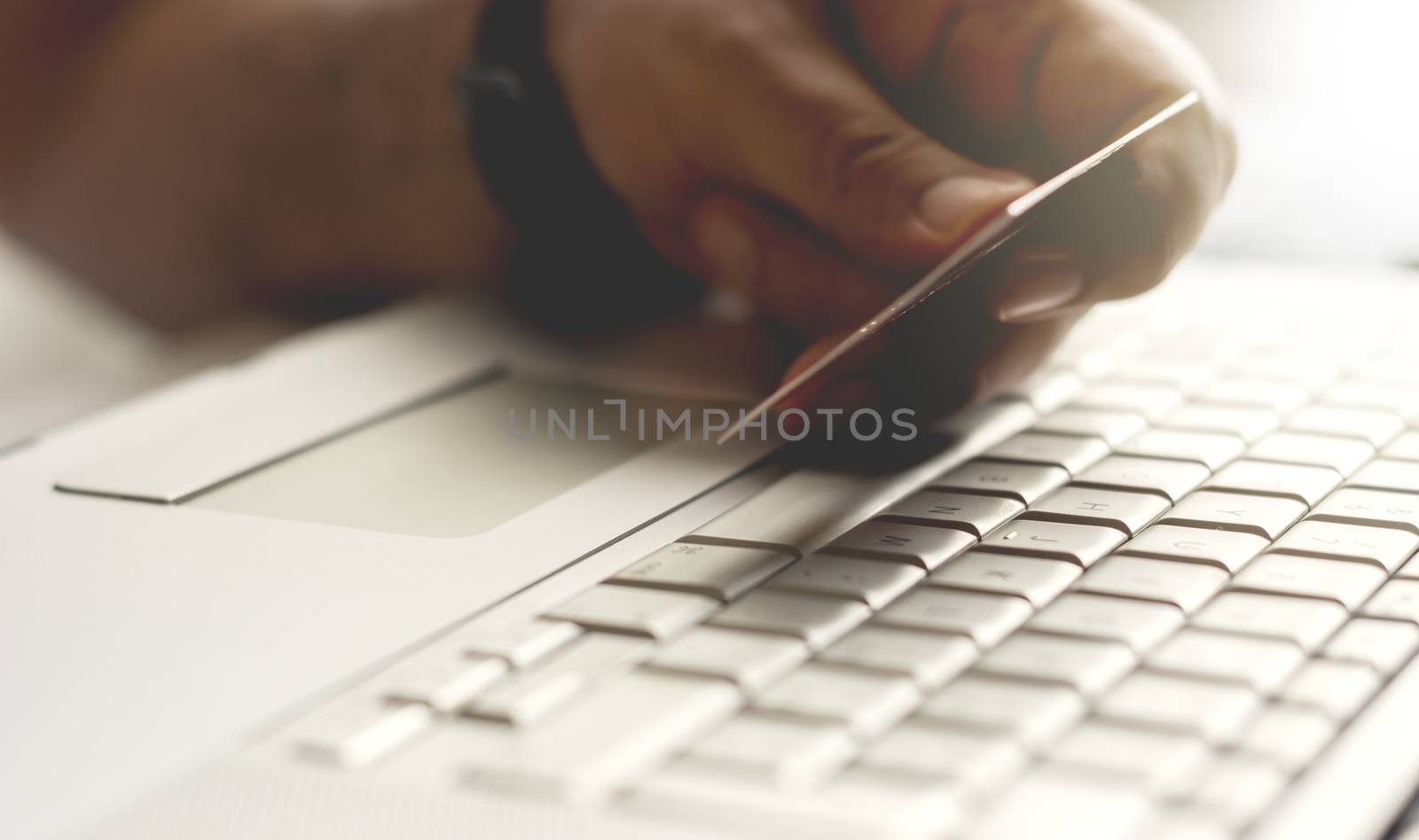 male hand holding a credit card during an internet payment transaction. Concept of e-commerce and online shopping.