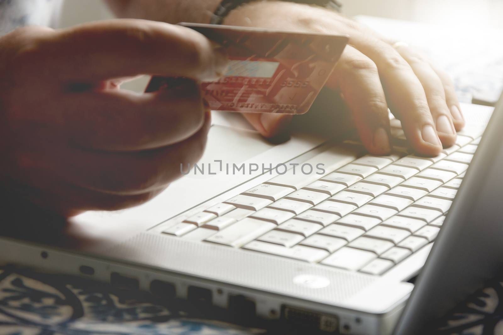 male hand holding a credit card during an internet payment transaction. Concept of e-commerce and online shopping.