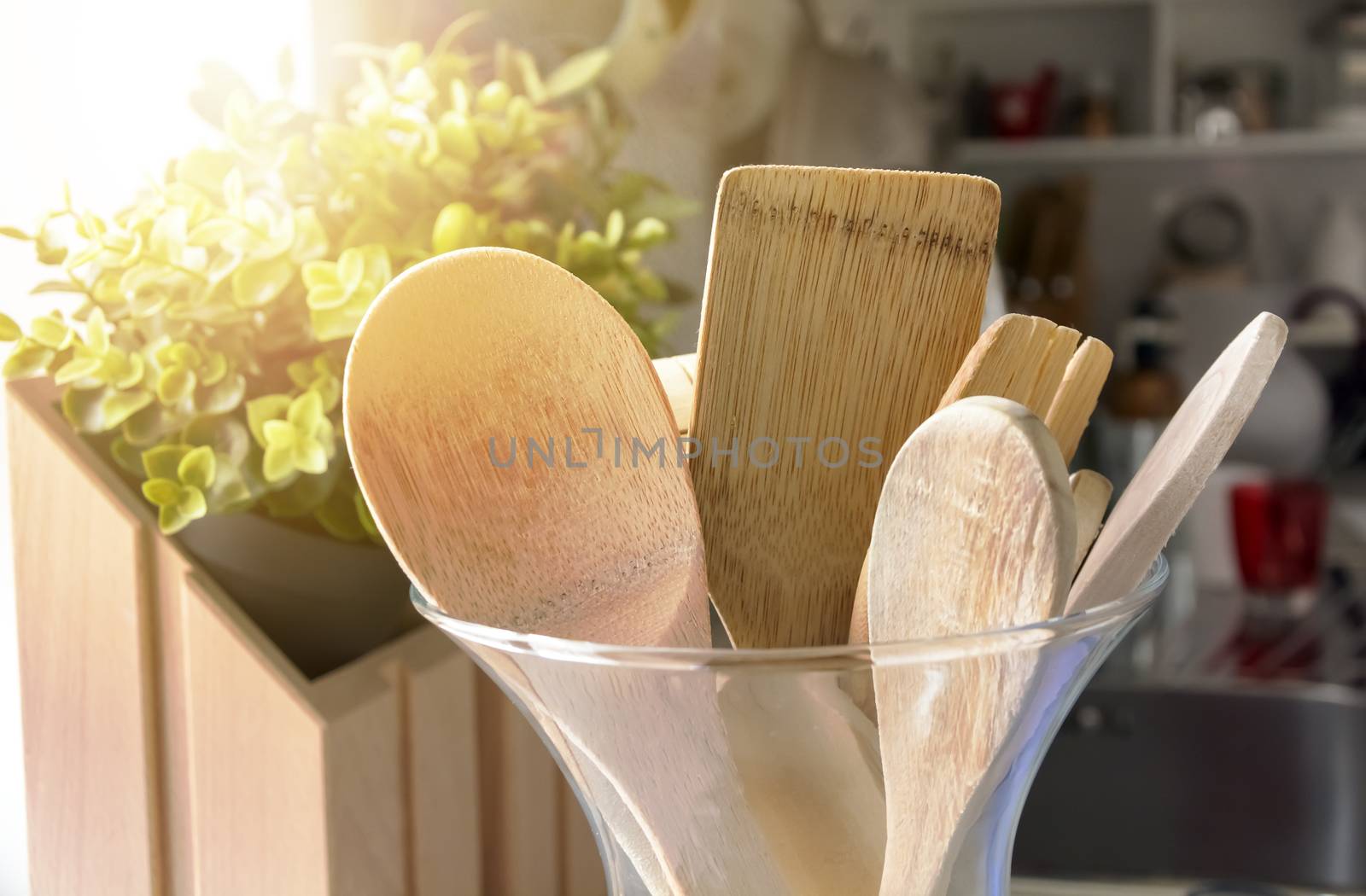 Close-up view of a group of wooden kitchen utensils inside a glass container. Cooking with traditional utensils