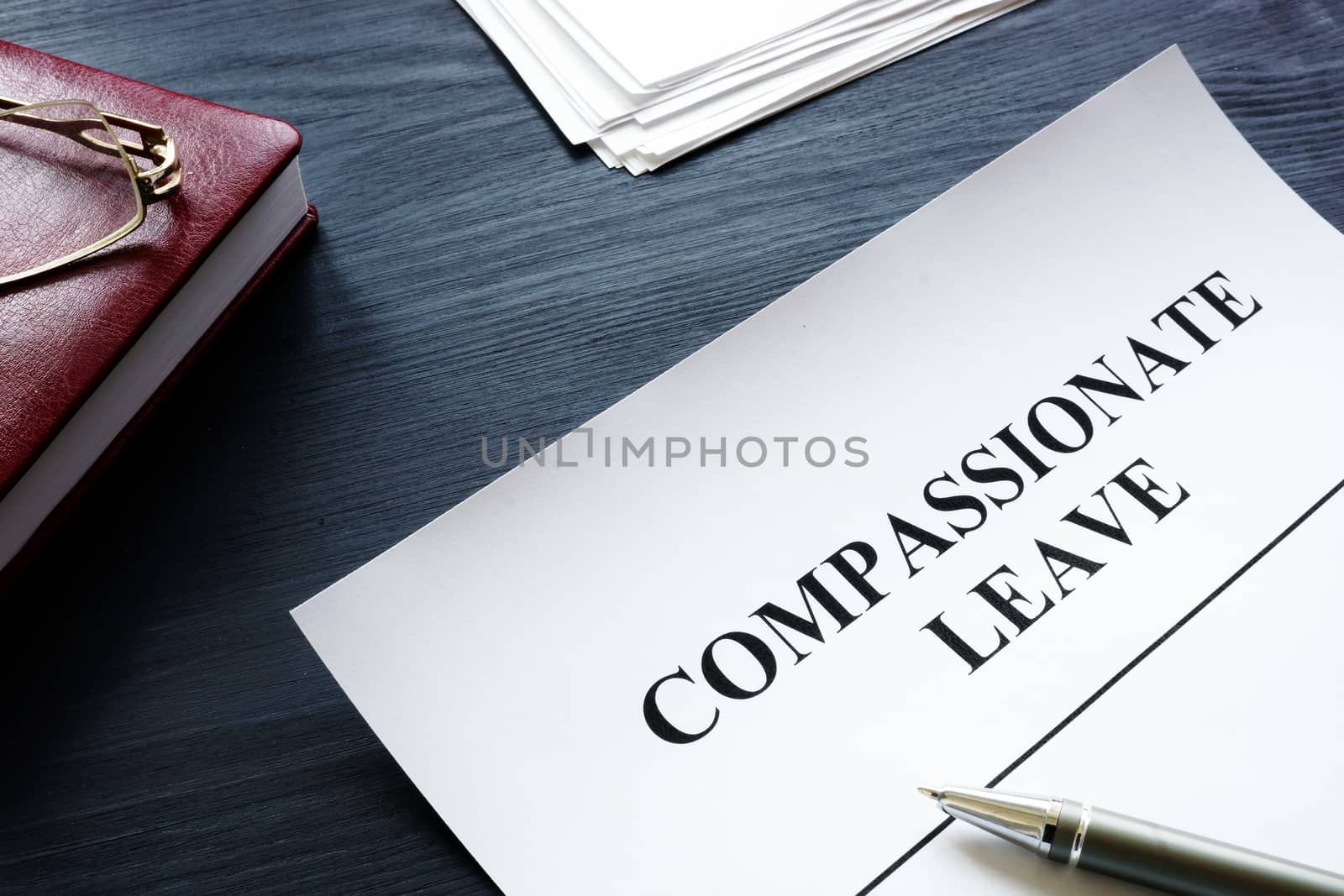 Compassionate leave request form with pen on the desk. by designer491