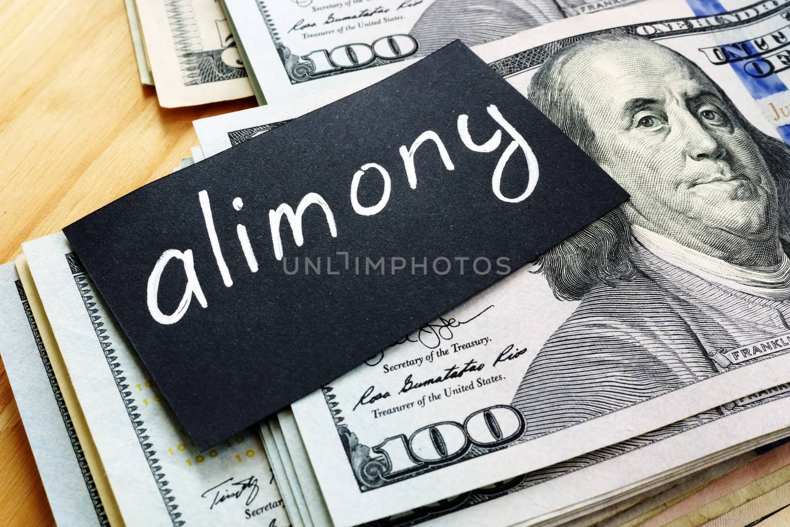 Alimony sign on a black piece of paper and money. by designer491