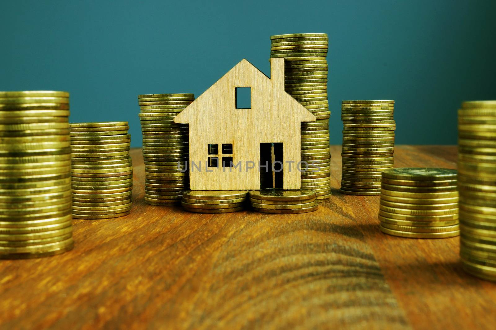 Investment Property or mortgage concept. Columns of money and wooden home.