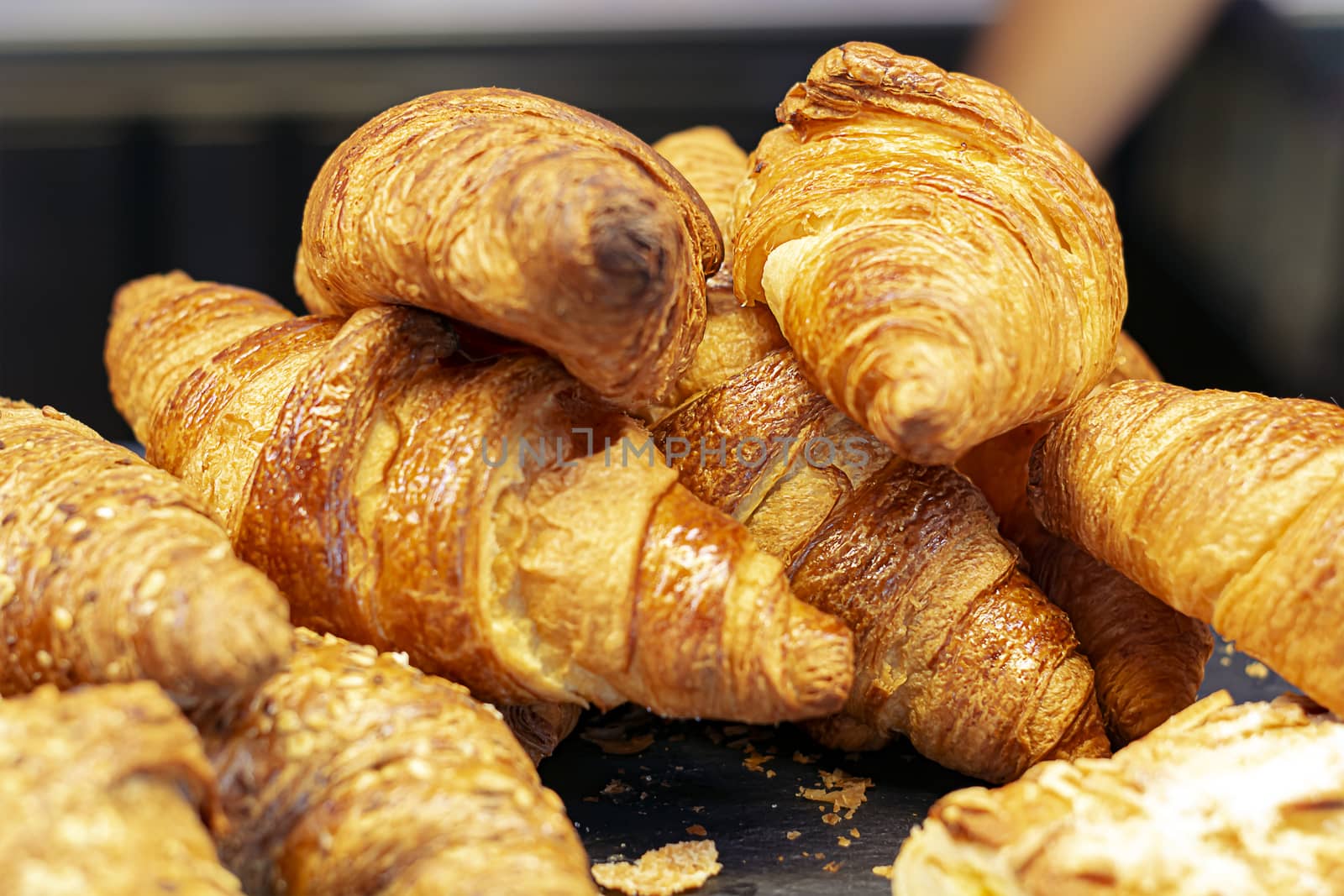 a group of croissants stacked on a tray. by rarrarorro