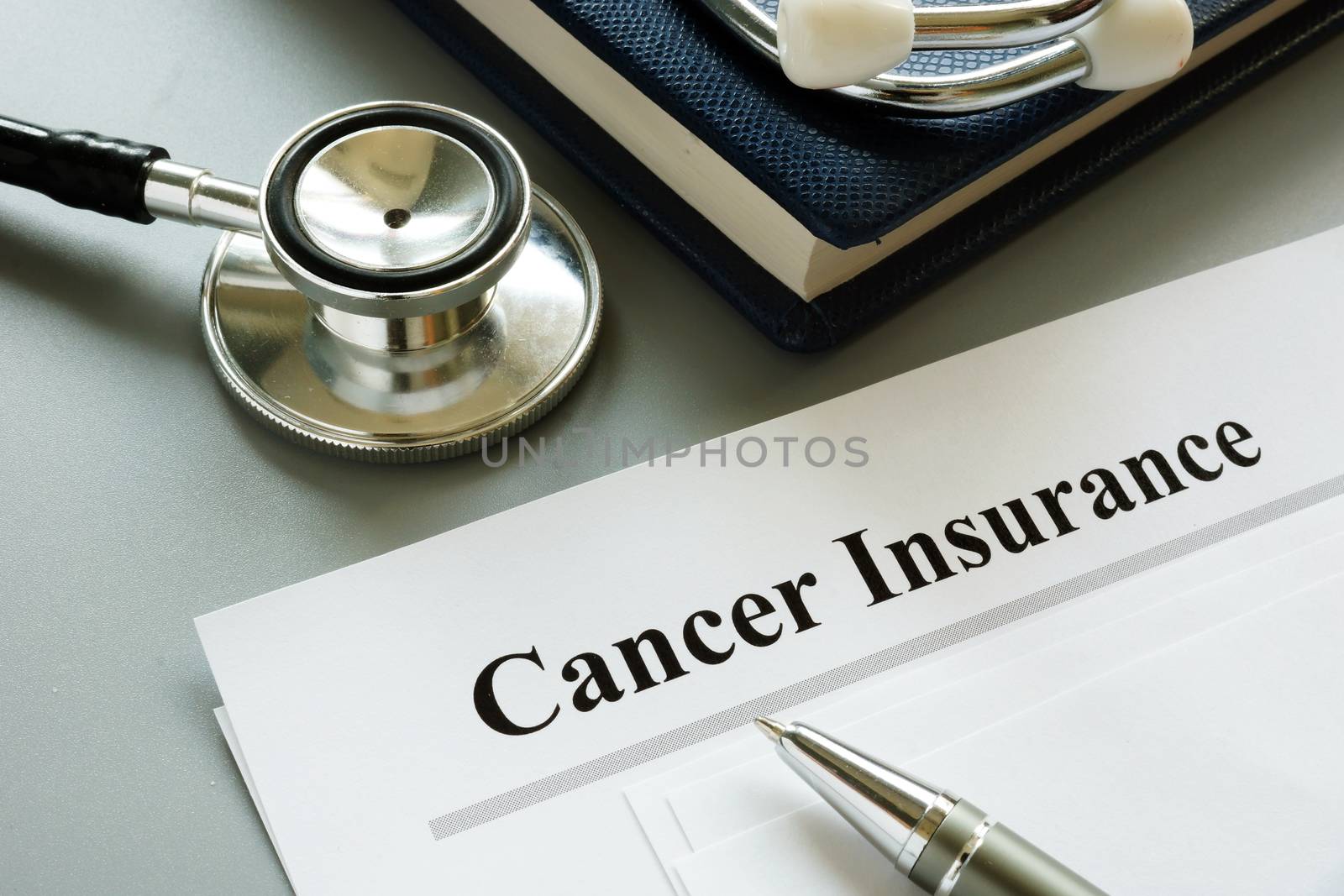 Cancer Insurance policy and stethoscope on a desk. by designer491