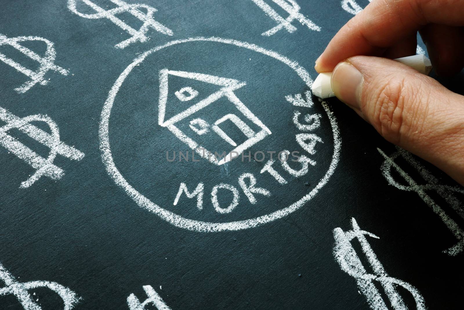 Hand is writing word mortgage by chalk. by designer491