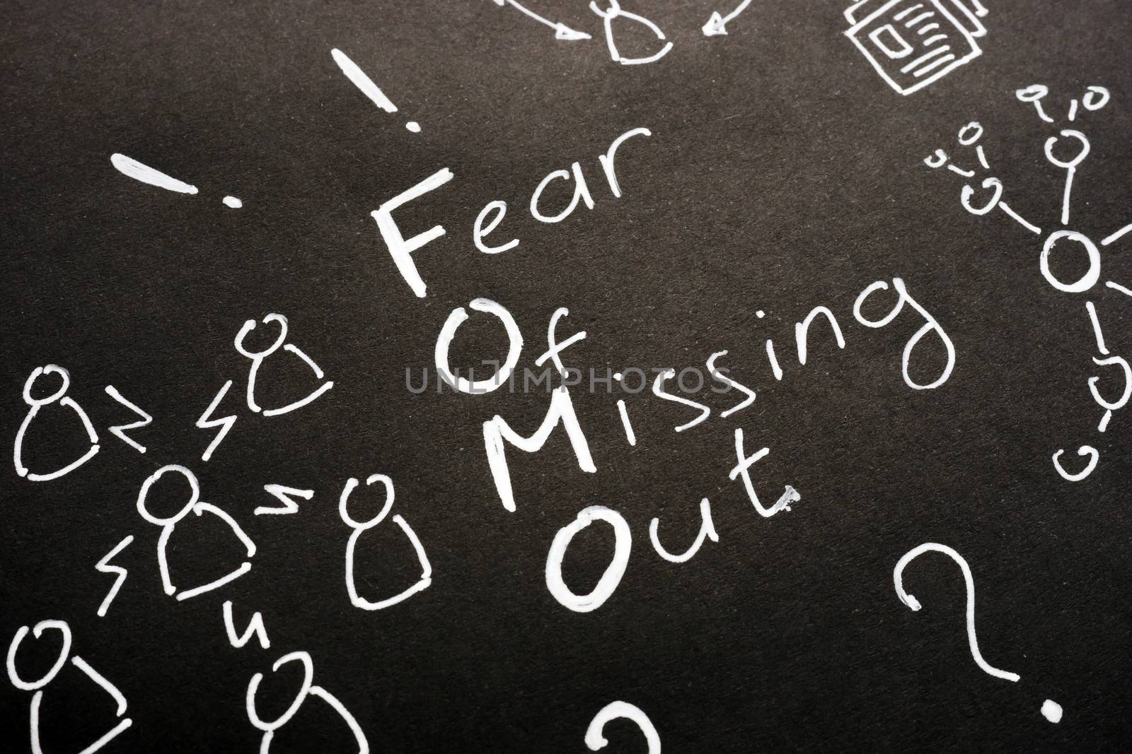 FOMO - Fear Of Missing Out sign on black sheet. by designer491