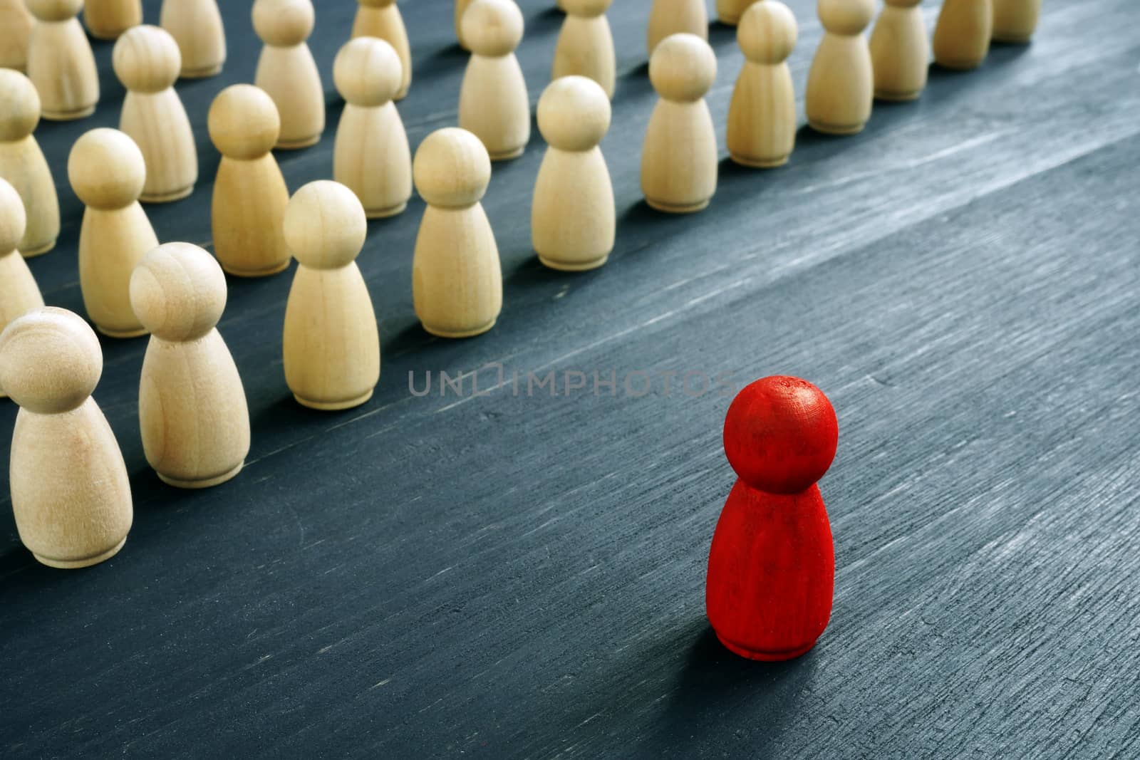 Leadership management concept. Red figure as leader opposite of wooden figures. by designer491