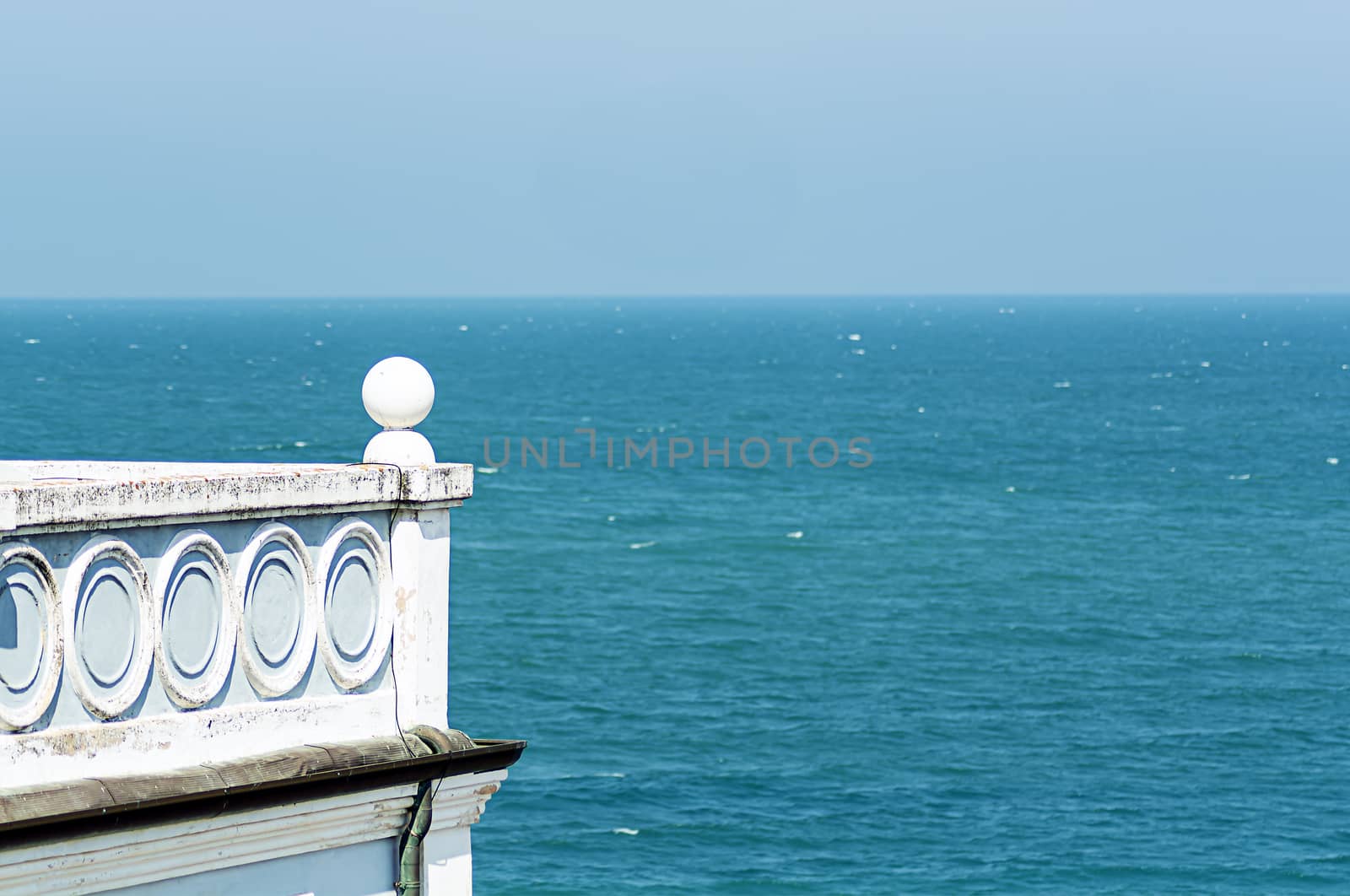 Ancient house with a decorated balcony overlooking the sea. Architecture and holidays.