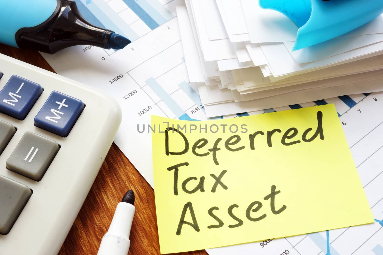 Deferred tax asset handwritten sign and calculator. by designer491