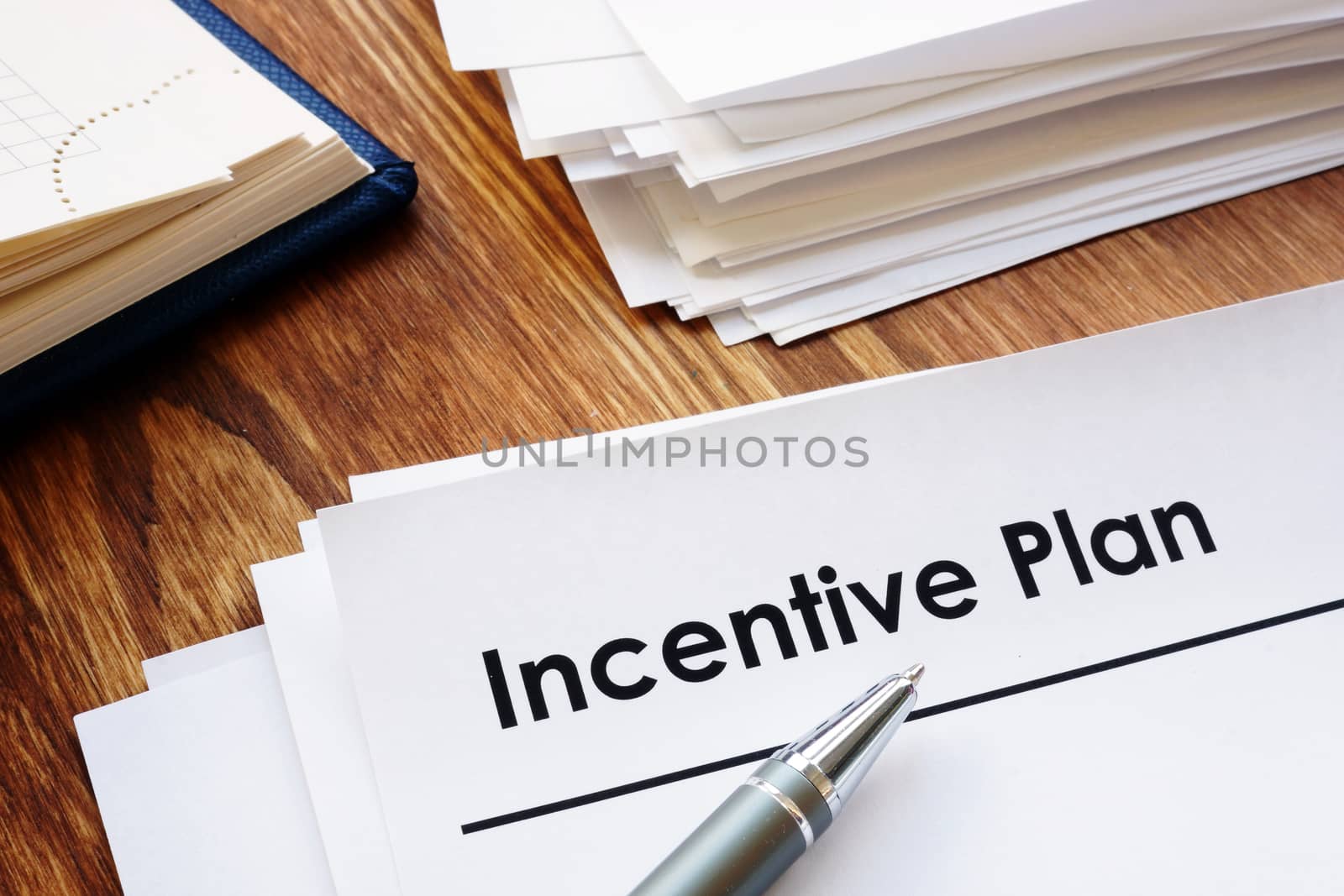Incentive Plan and stack of papers in the office. by designer491