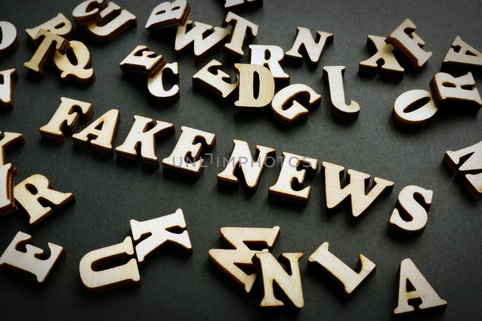 Fake news concept. Letters on the black desk. by designer491