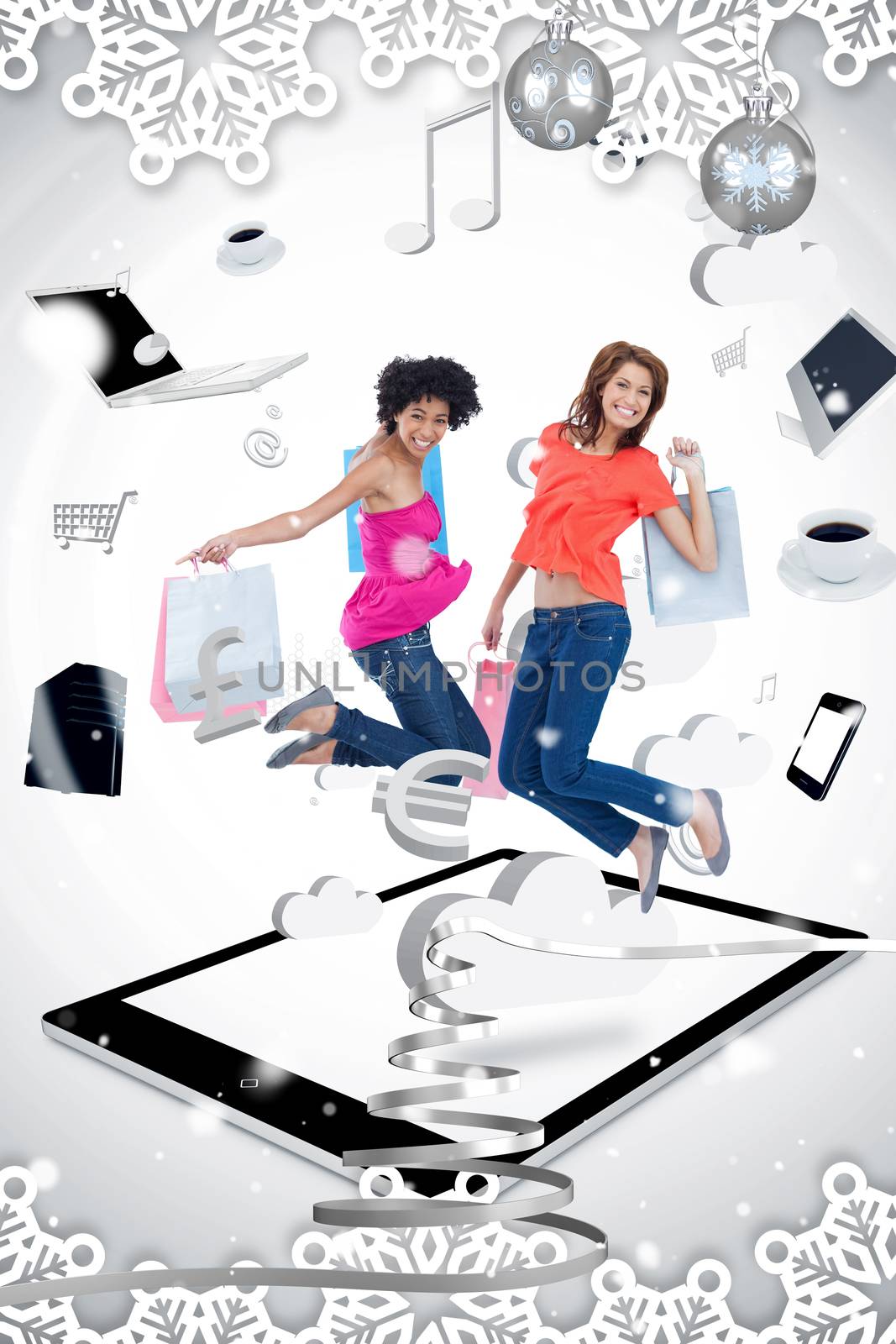 Two smiling women jumping on a tablet pc  against snow falling