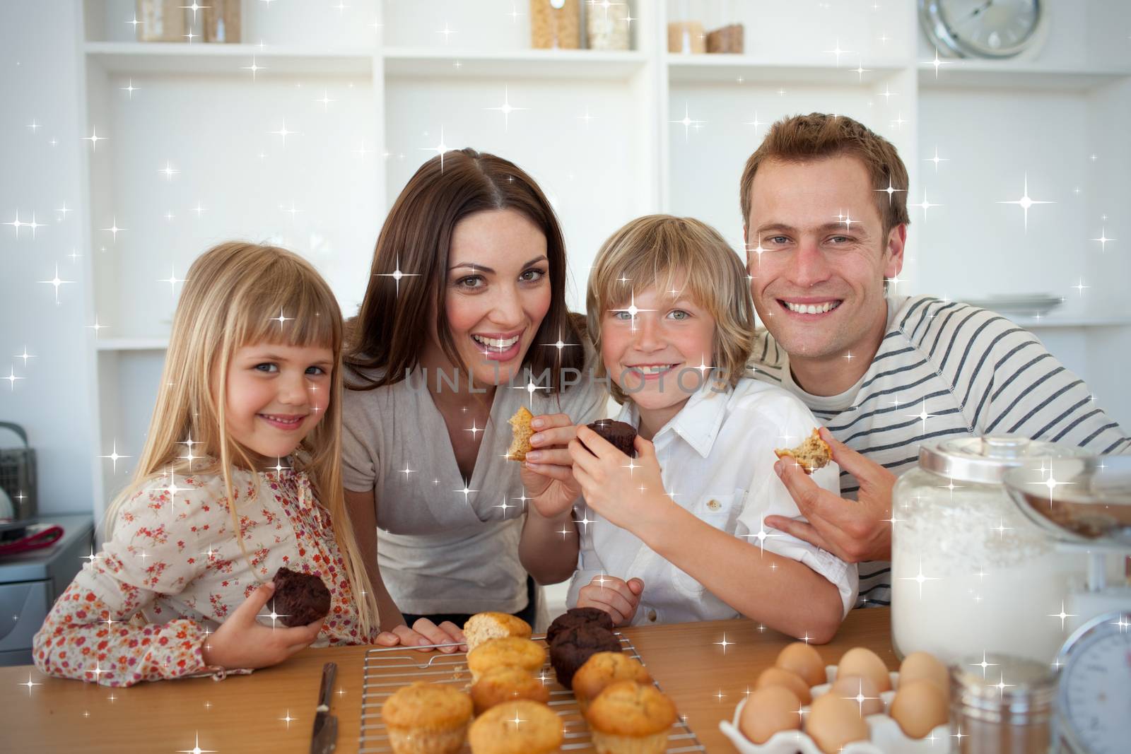 Cute children eating muffins with their parents by Wavebreakmedia
