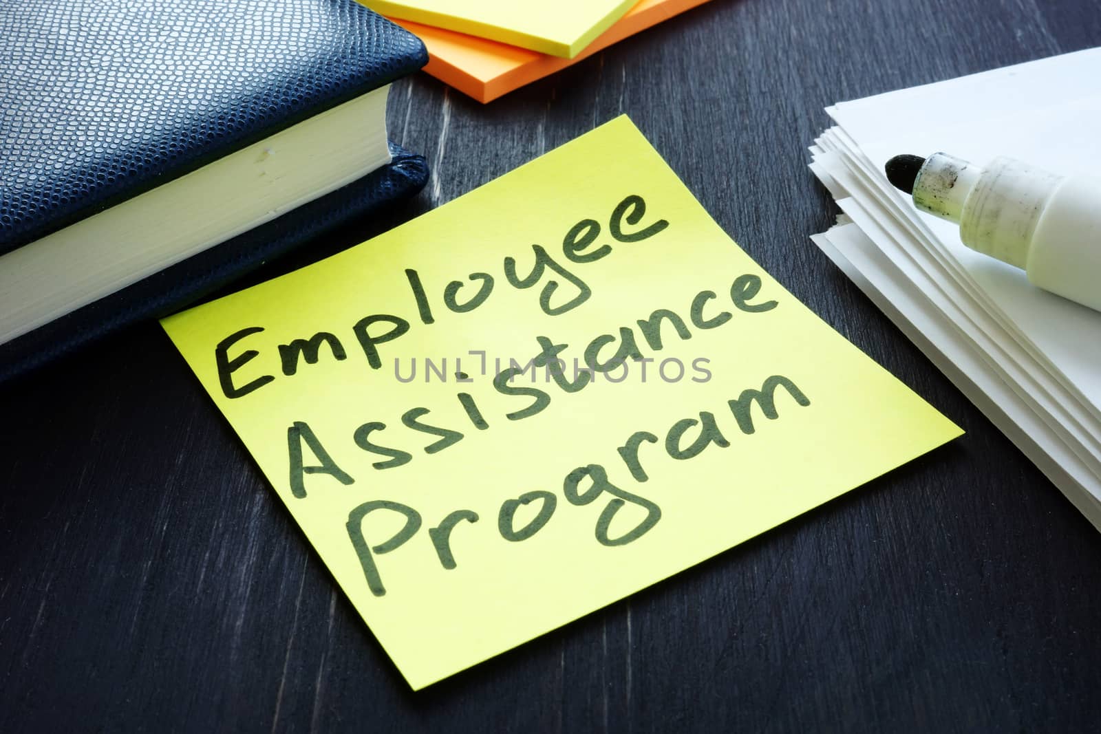 Employee assistance program EAP sign and pile of papers. by designer491