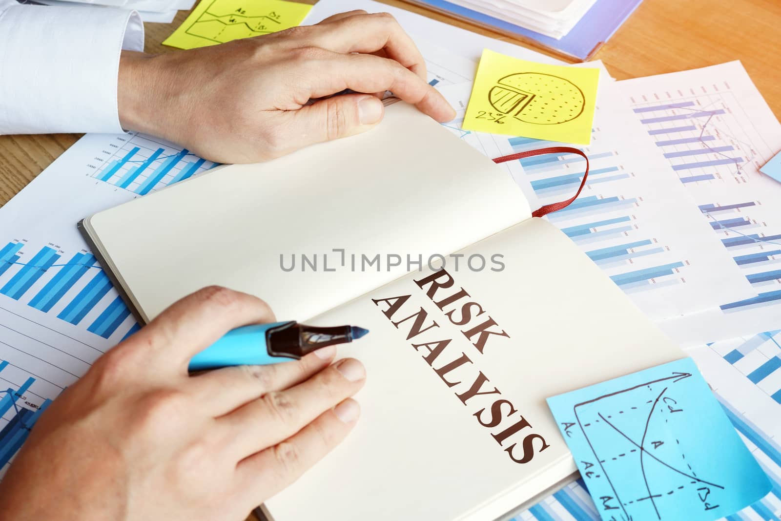 Businessman reads risk analysis report in the office. by designer491