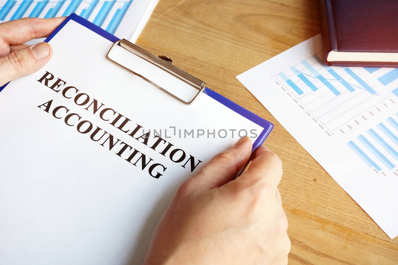 Reconciliation accounting papers in the accountant hand. by designer491