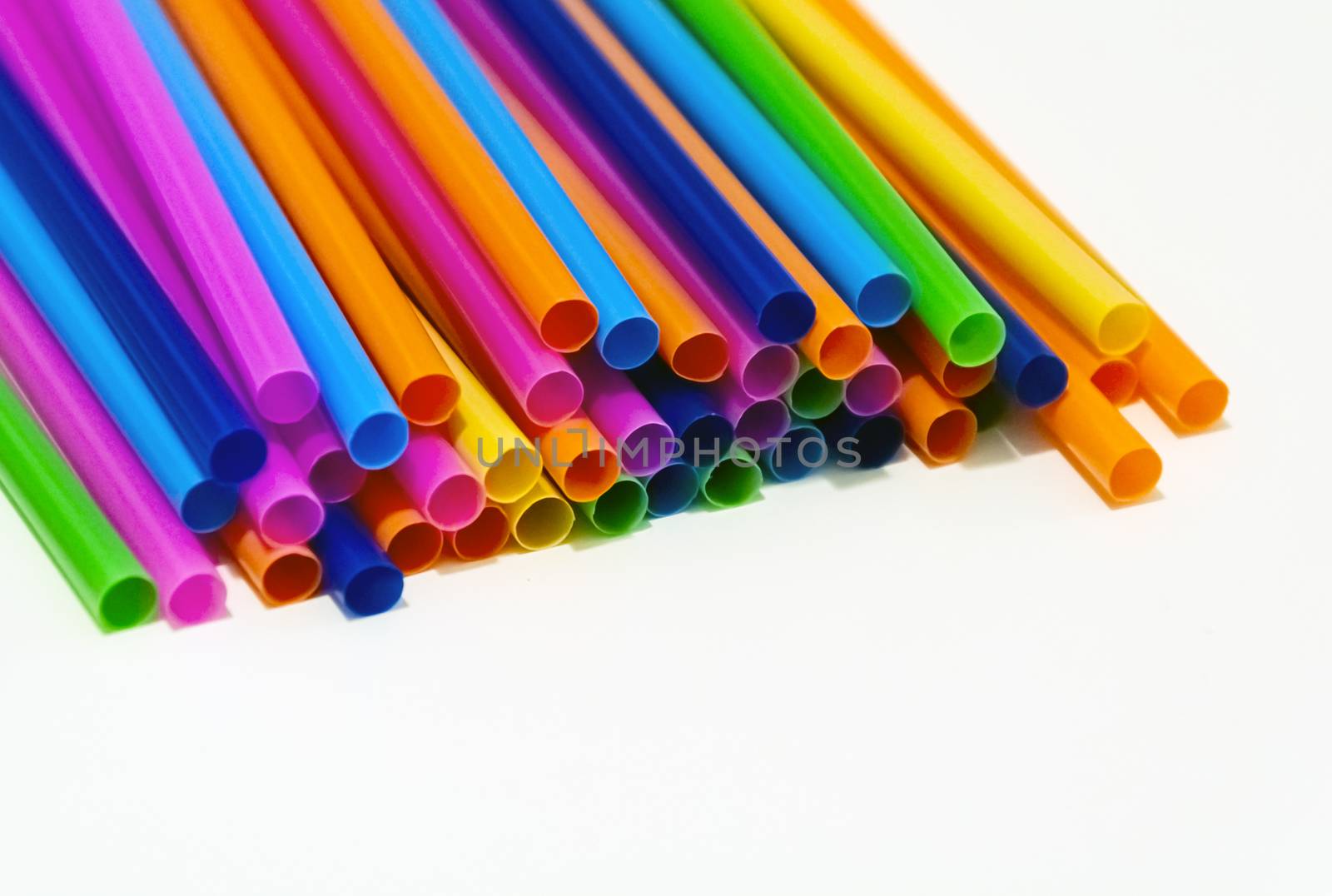 group of plastic straws of various colors on a white background. by rarrarorro