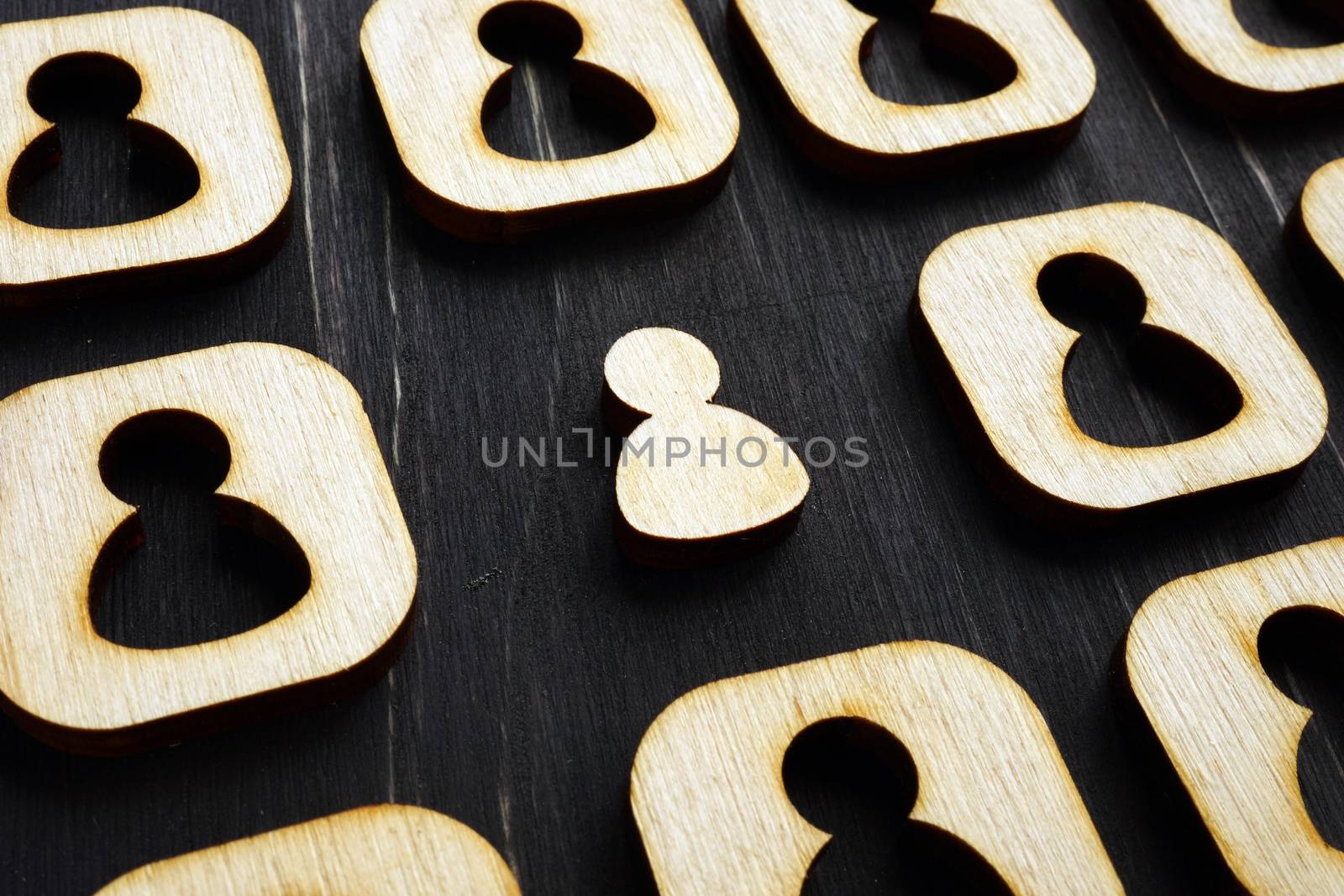 Unique stand out of the crowd. Wooden figures on the dark surface. by designer491