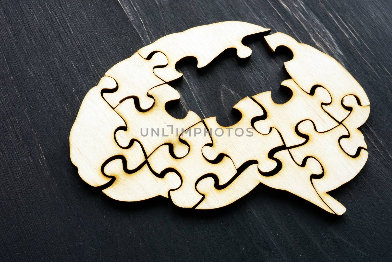 Alzheimers disease concept. Brain from wooden puzzles without one. by designer491