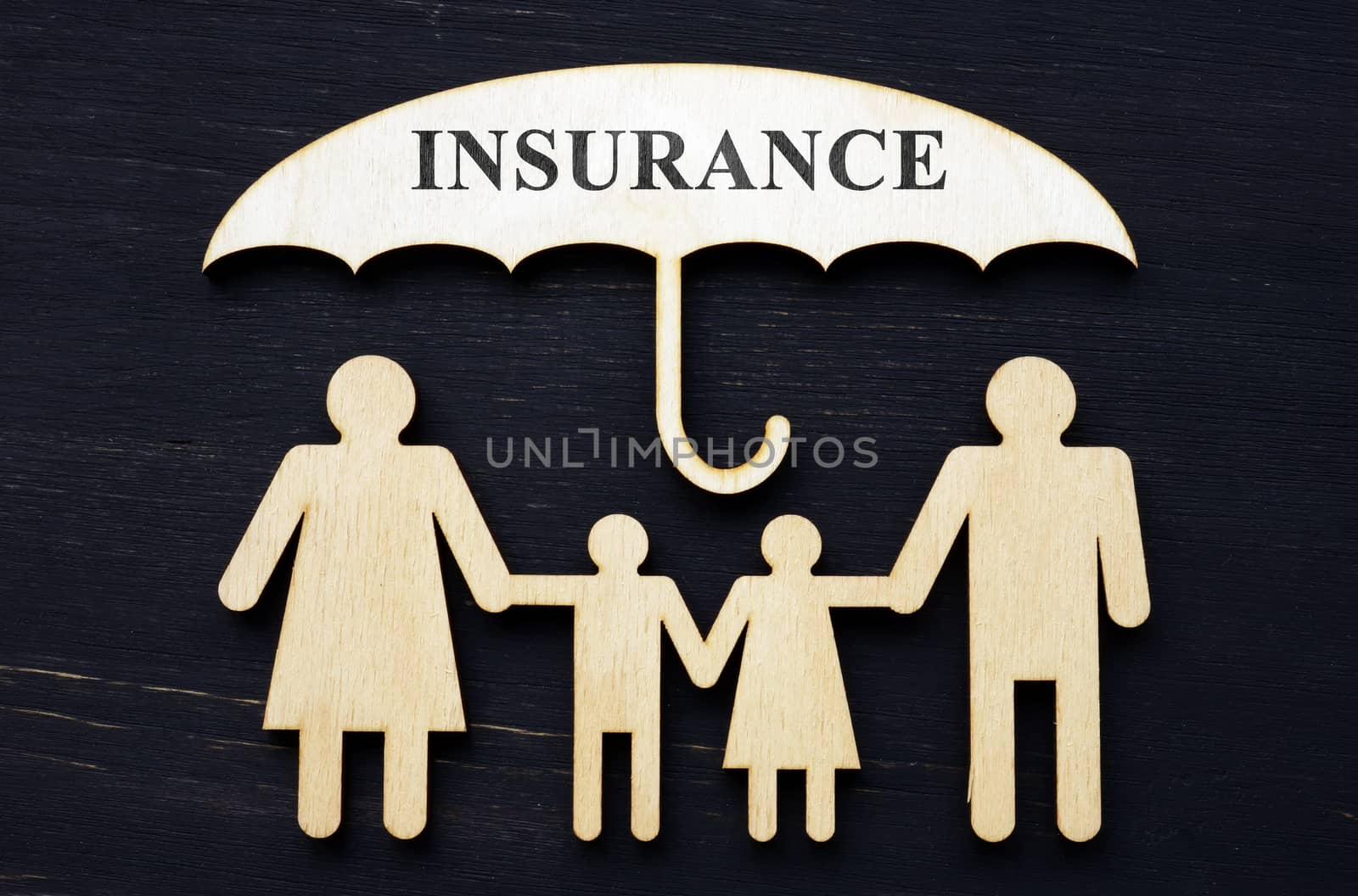 Life insurance concept. Figurines of a family under an umbrella. by designer491