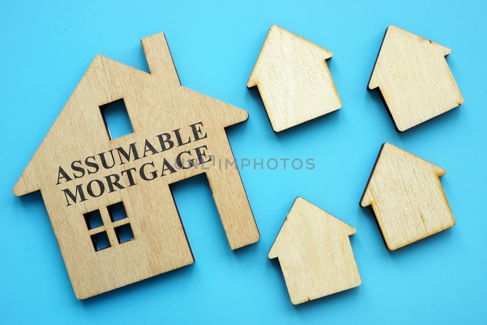 Assumable Mortgage sign on small model of house. by designer491