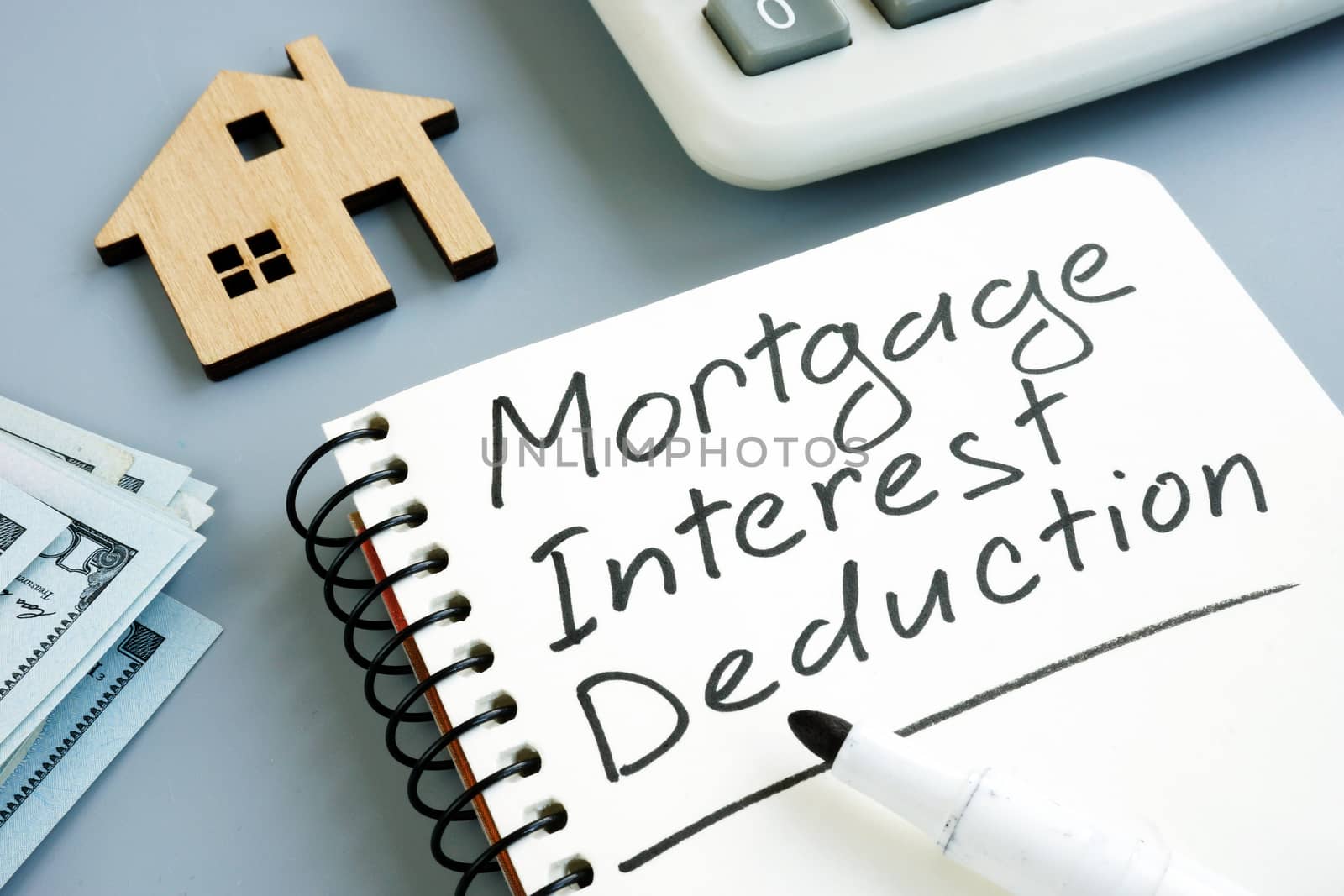 Mortgage Interest Deduction concept. Model of home and calculator.