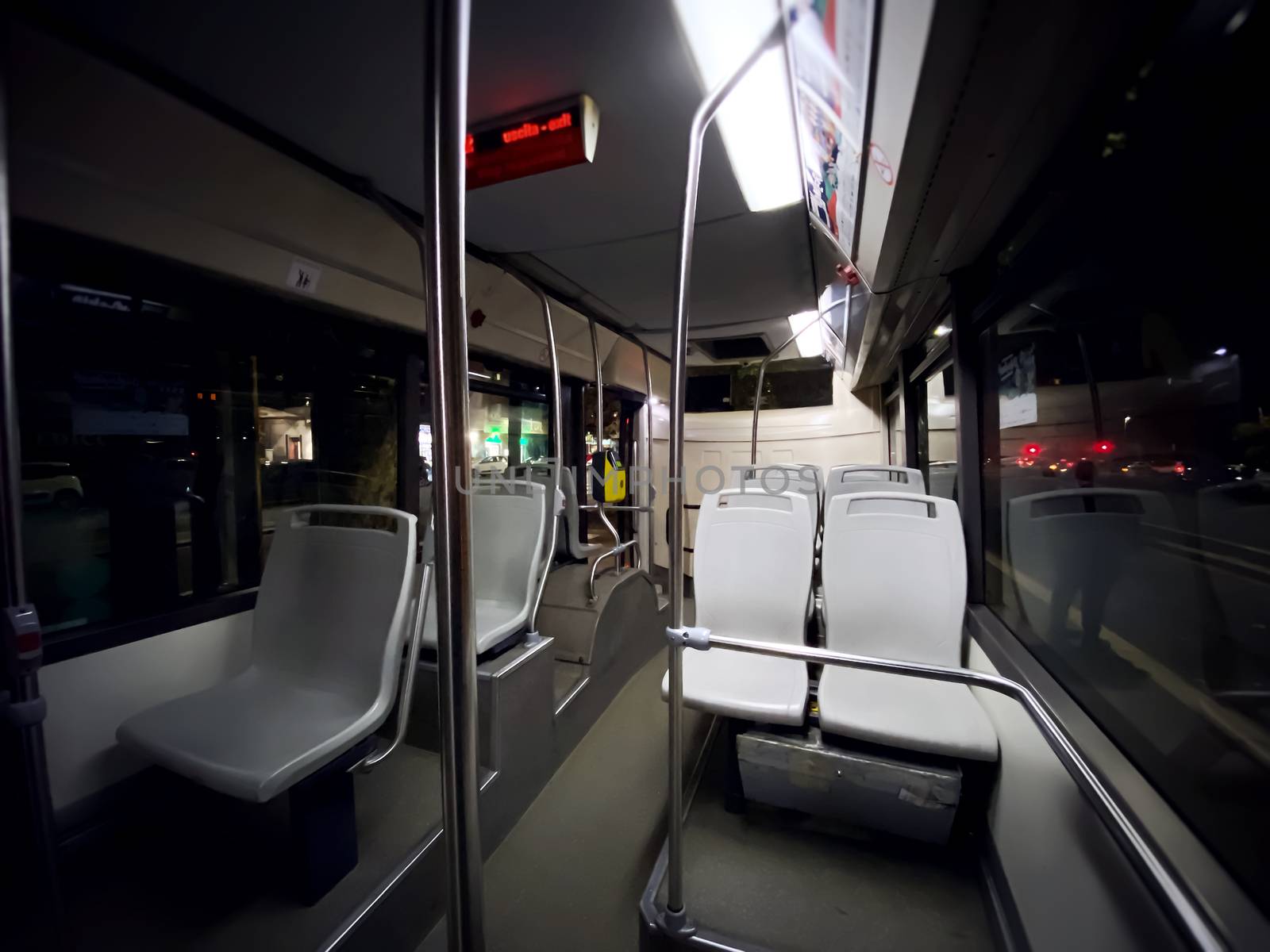 interior of a public transport bus with empty gray seats and no passengers. by rarrarorro