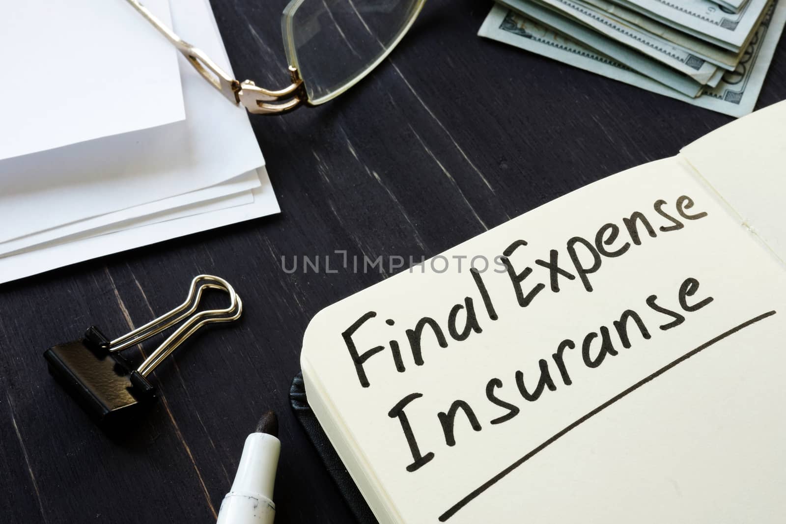 Final expense insurance memo in the black notepad.