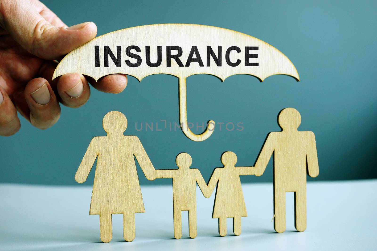 Life insurance concept. Figures of family and umbrella.