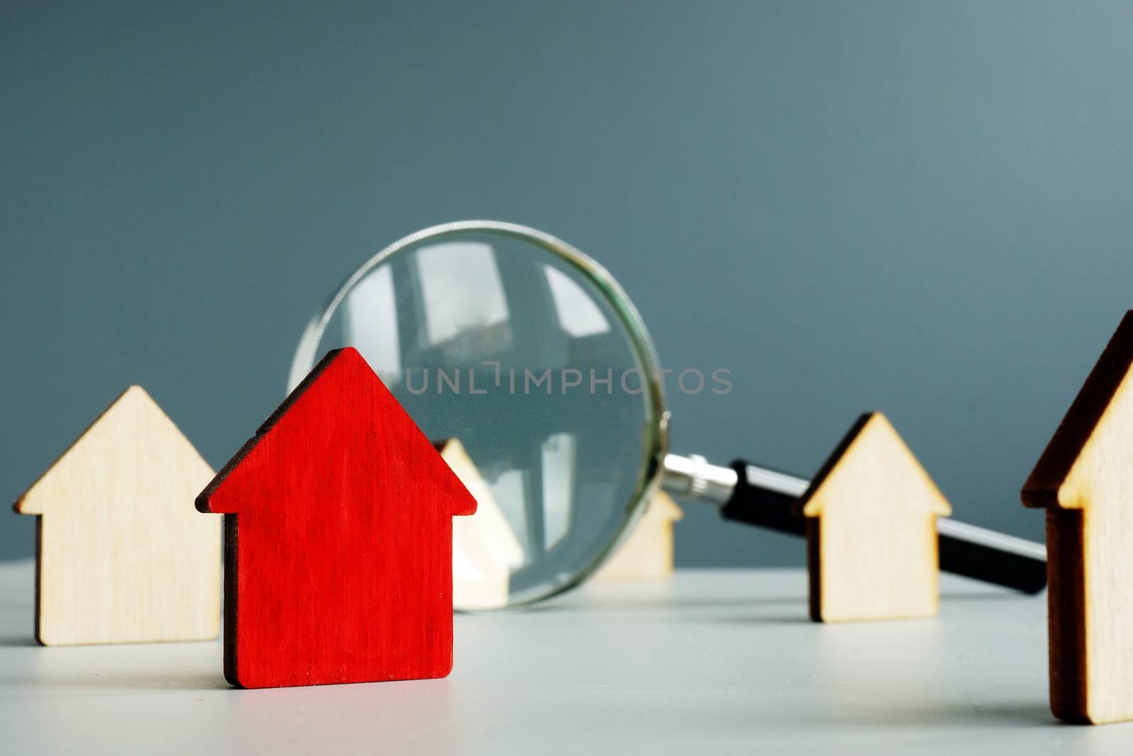 Home worth and property value concept. Magnifying glass and model of house. by designer491