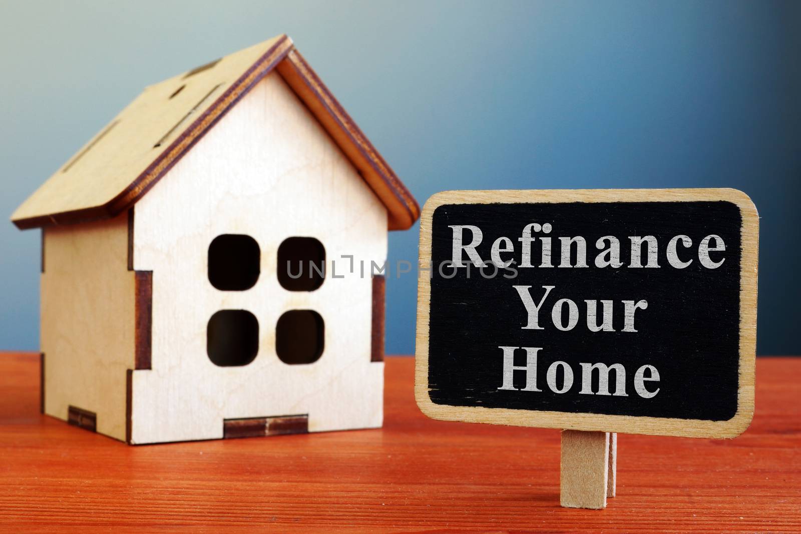Refinance Your Home mortgage board and wooden house. by designer491