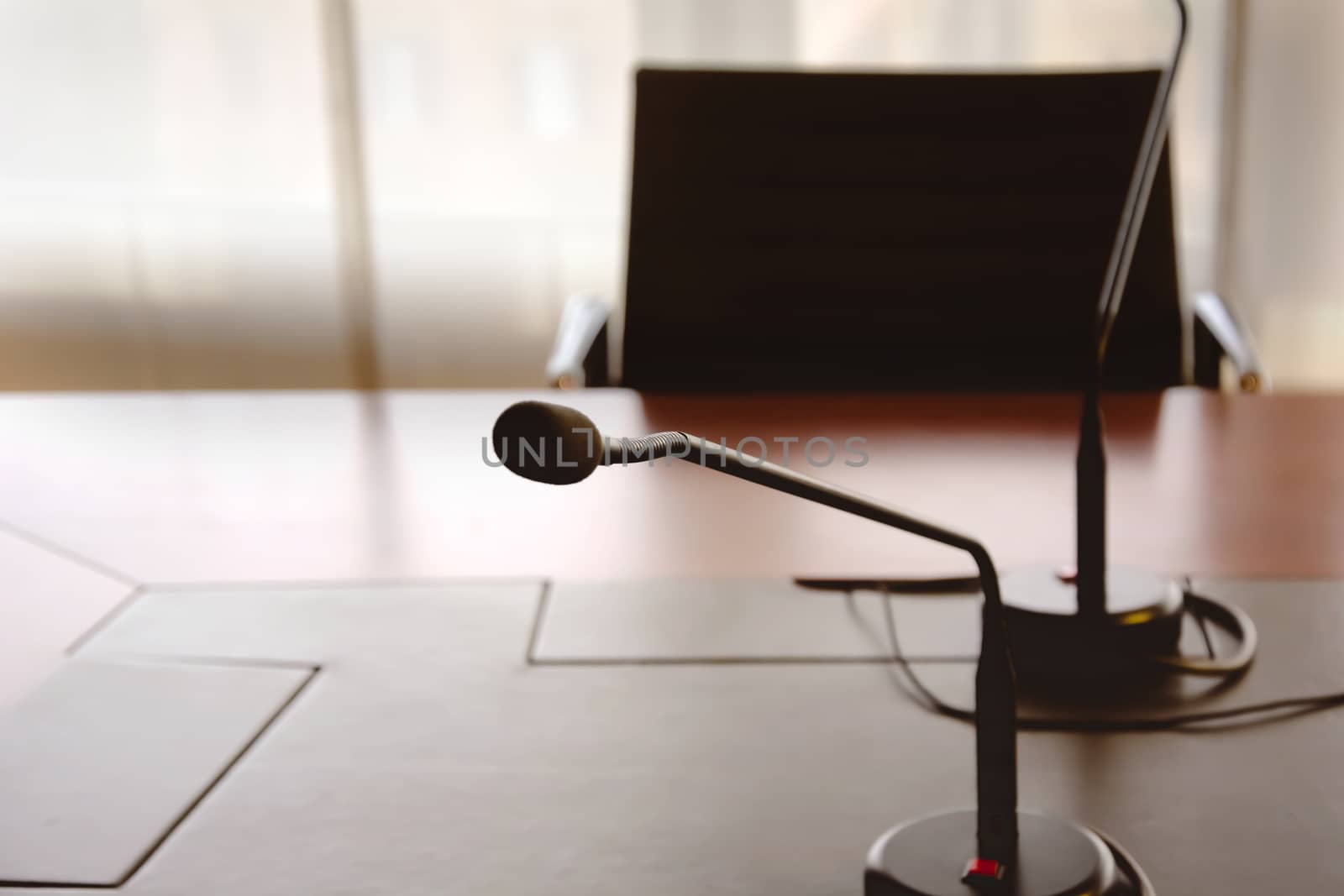 microphone on a wooden table and an empty chair in a boardroom by rarrarorro