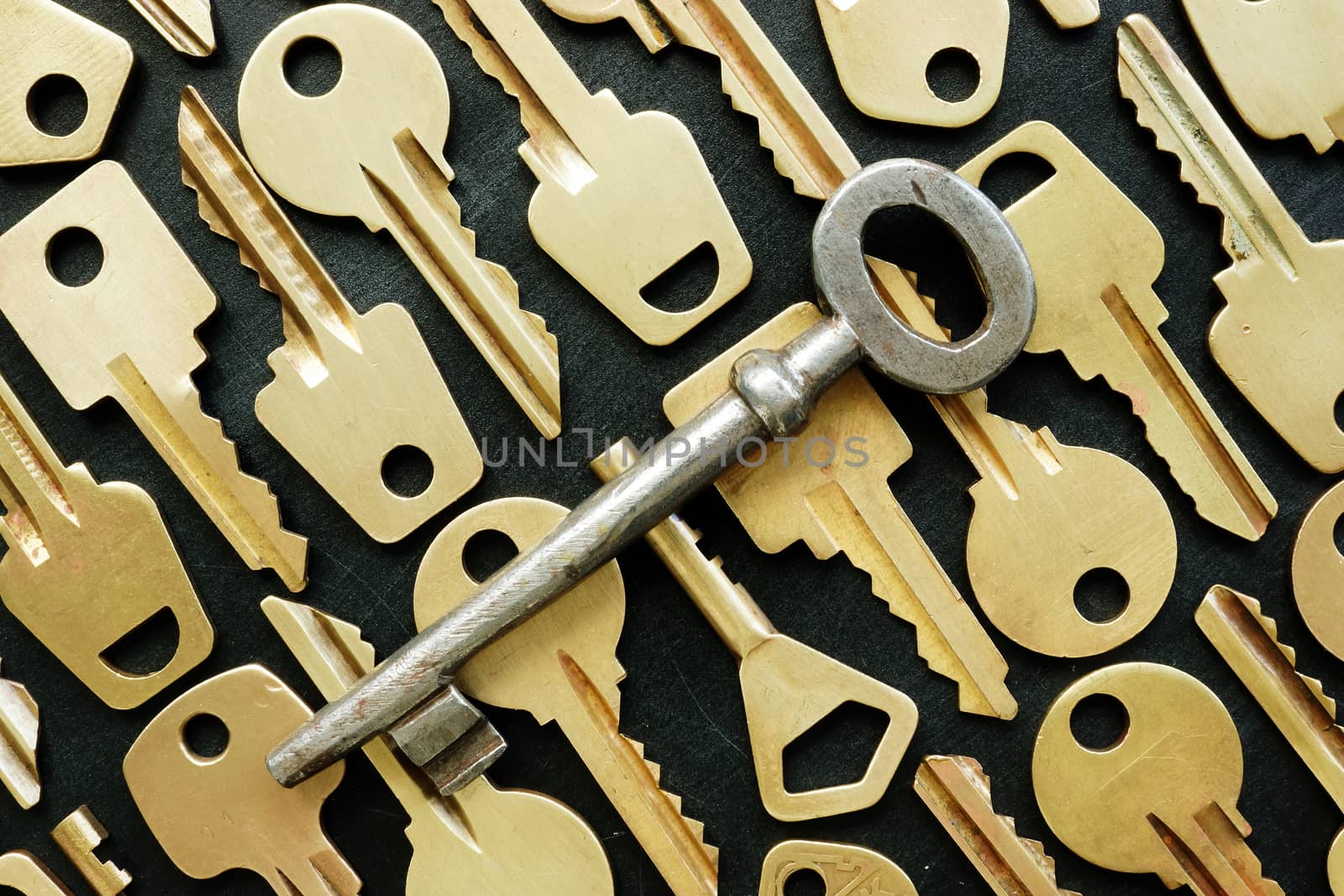Old metal key and many yellow ones as symbol of right decision or find the key.