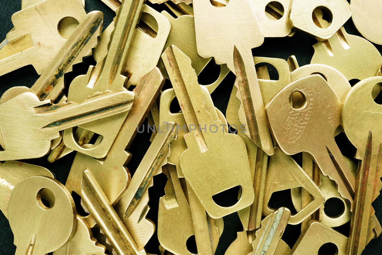 Closeup of pile of various yellow keys. Find right decision or possibilities concept.