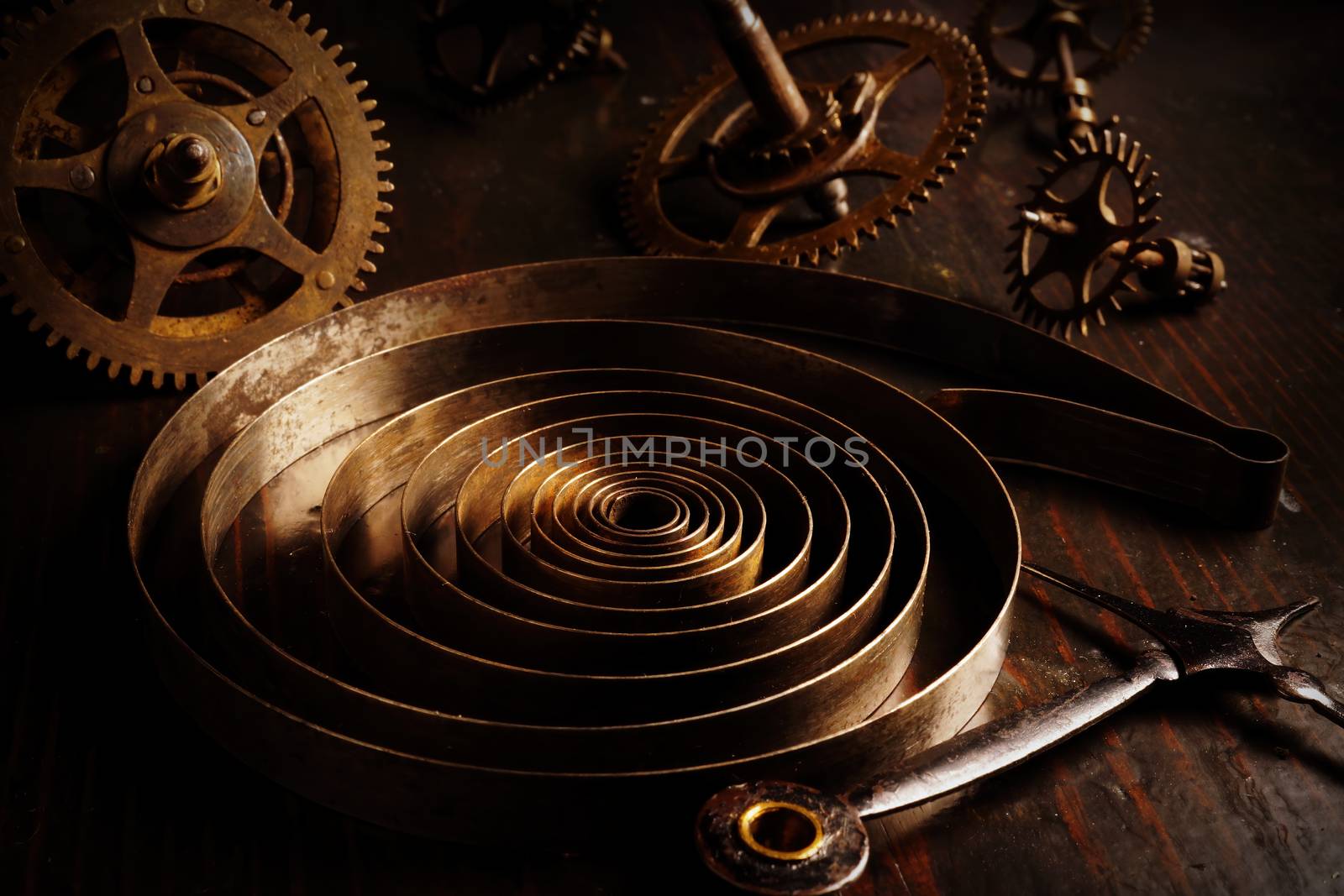 Old rusty watch parts with gear wheels in the dark. Repair of vintage brass clock.
