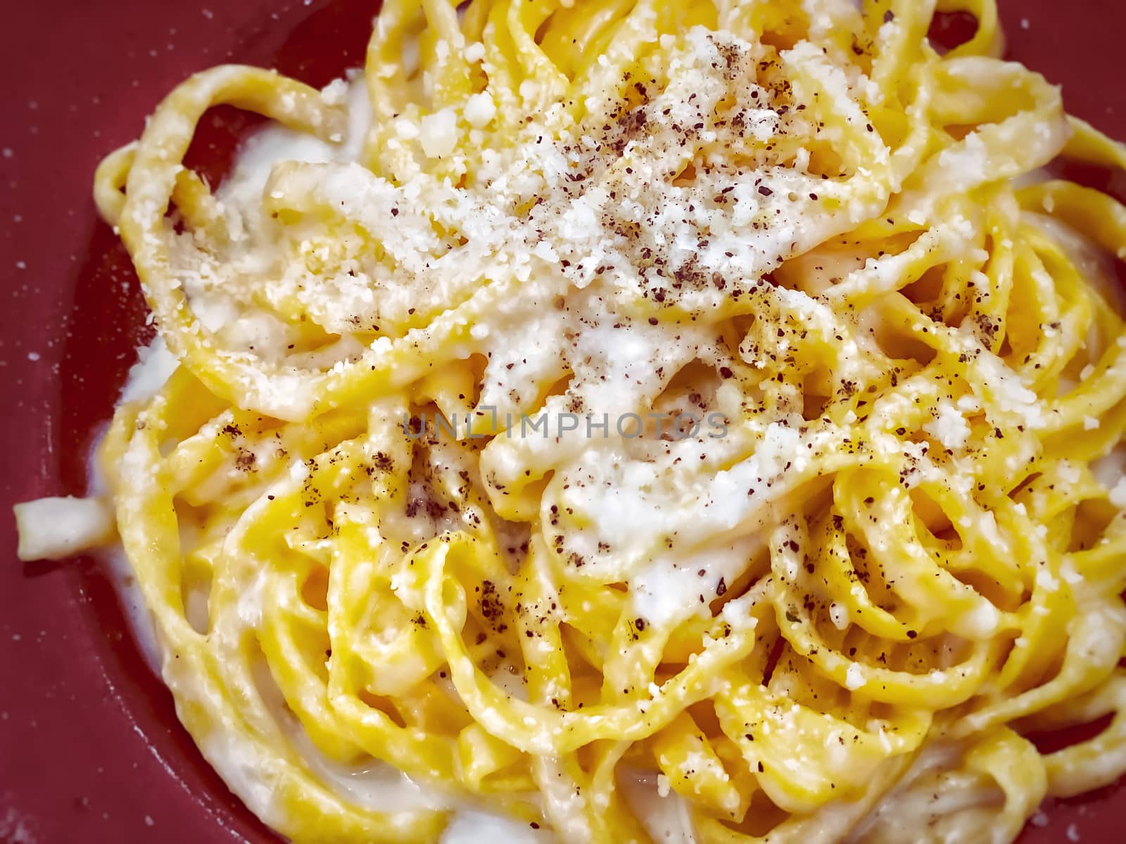 A portion of Italian traditional pasta with cacio e pepe - cheese and pepper- sauce by rarrarorro
